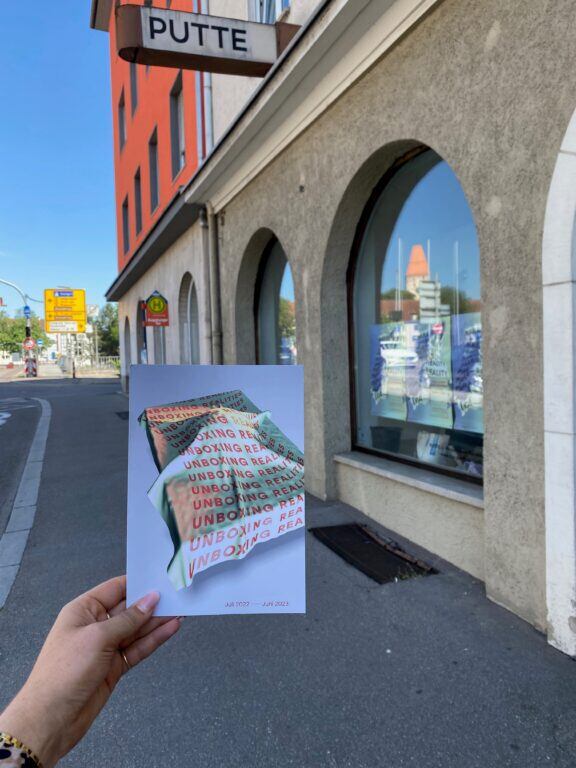 Flyer für die neue Ausstellung Para-Reality vor der Putte